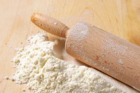 Flour and rolling pin on a wooden board